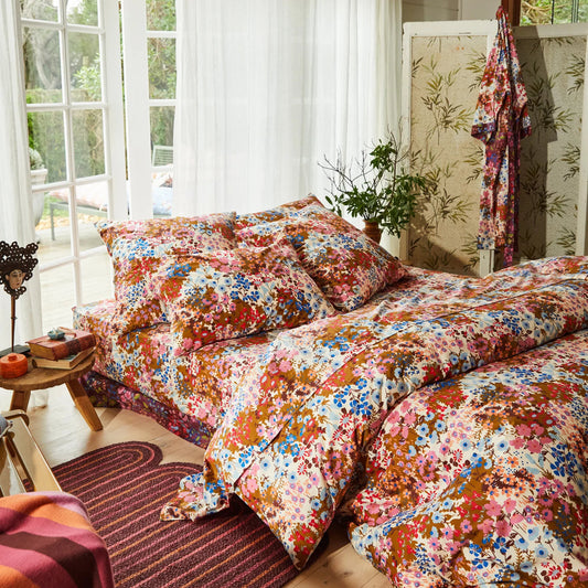 Floral bedding set in a bright bedroom with a window.