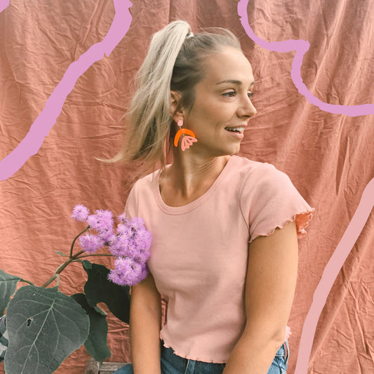 Woman wears pink and red earrings