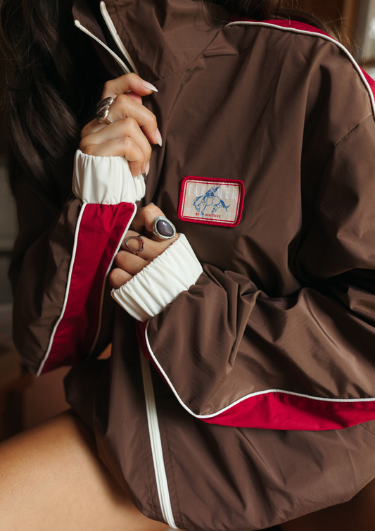 Brown jacket with red and white trim and a visible brand logo.