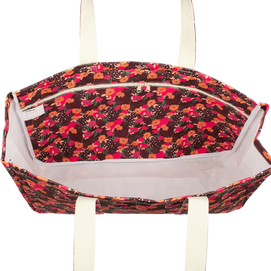 Floral patterned bag with white handles on a white background