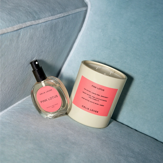 Cela Lover Pink Lotus candle and perfume bottle on a light blue surface