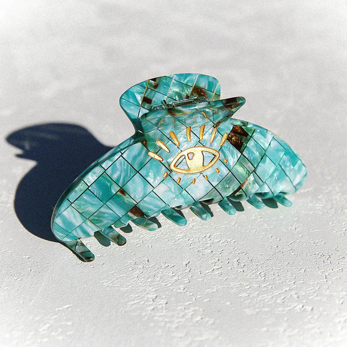 Green claw clip in tortoise print with flecks of brown and gold eye detail.