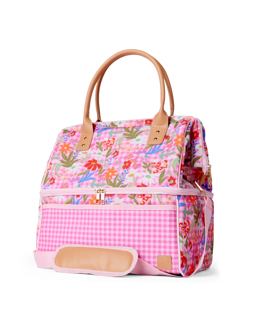 Floral and checkered patterned bag with brown handles on a white background