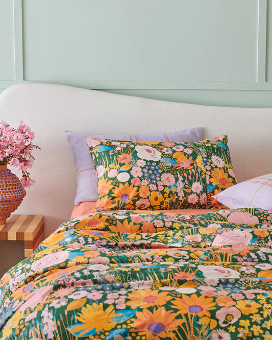Floral bedding set on a bed with a light blue wall in the background