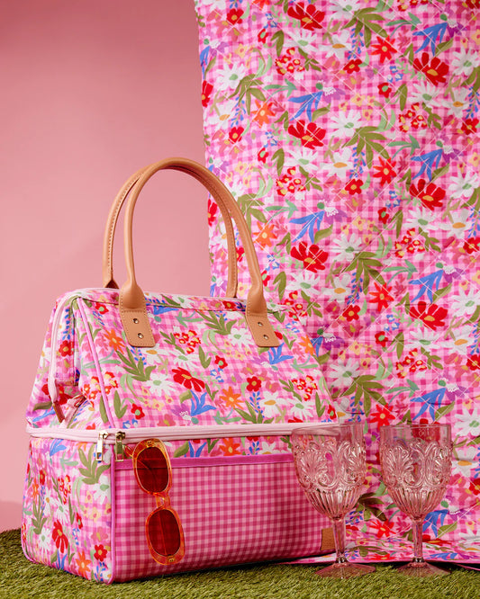 Floral-patterned handbag with sunglasses and glasses on a pink floral background