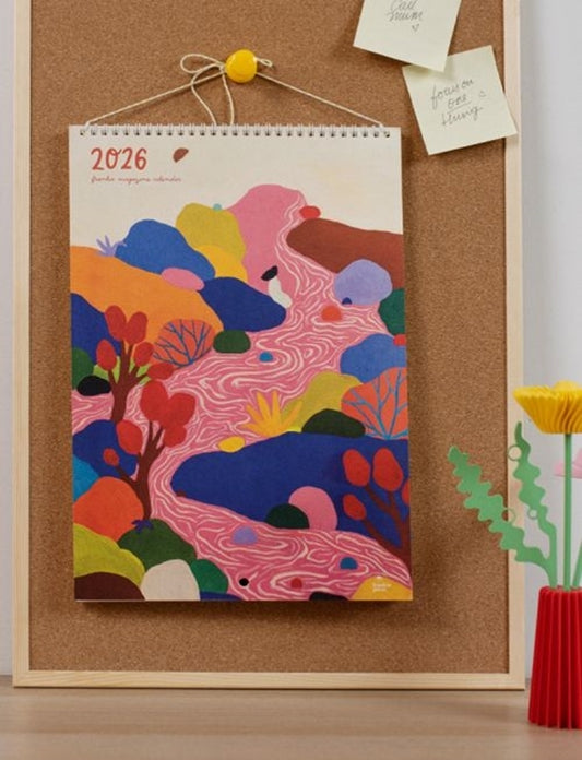 Colorful abstract design calendar hanging on a cork bulletin board.