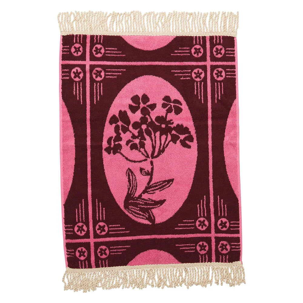 Decorative hand towel with floral design and fringe on a white background