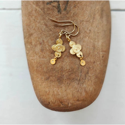 Gold Earwire, with four point gold detailed pendant and small circle hanging from bottom of earring, captured on natural timber surface and white background.