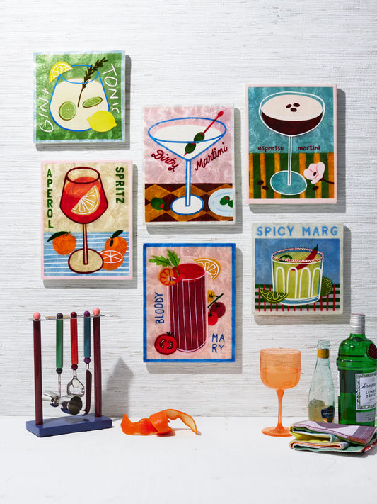 Set of colourful cocktail-themed wall art on a white textured wall.