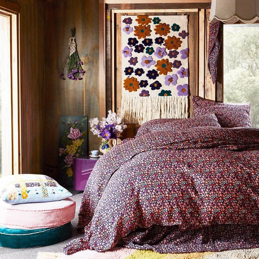 Bedroom with floral bedding and wall hanging