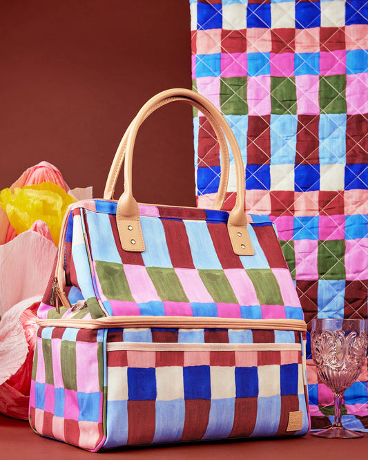 Colorful checkered handbag with wooden handle on a patterned background
