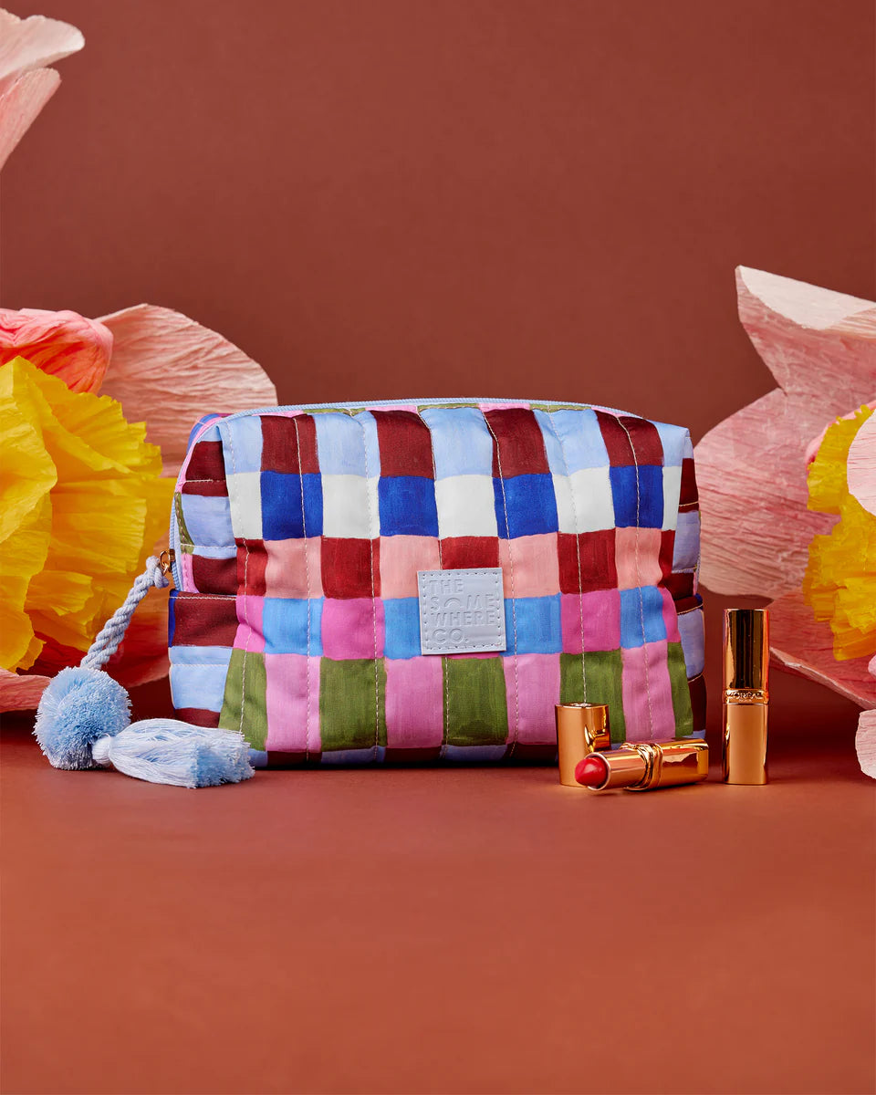Colorful patchwork pouch with lipsticks on a brown background