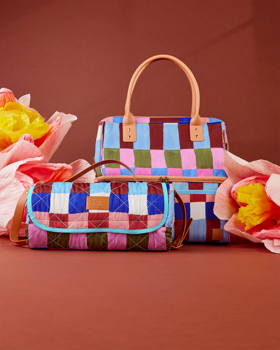 Colorful quilted handbag with a checkered pattern on a brown background