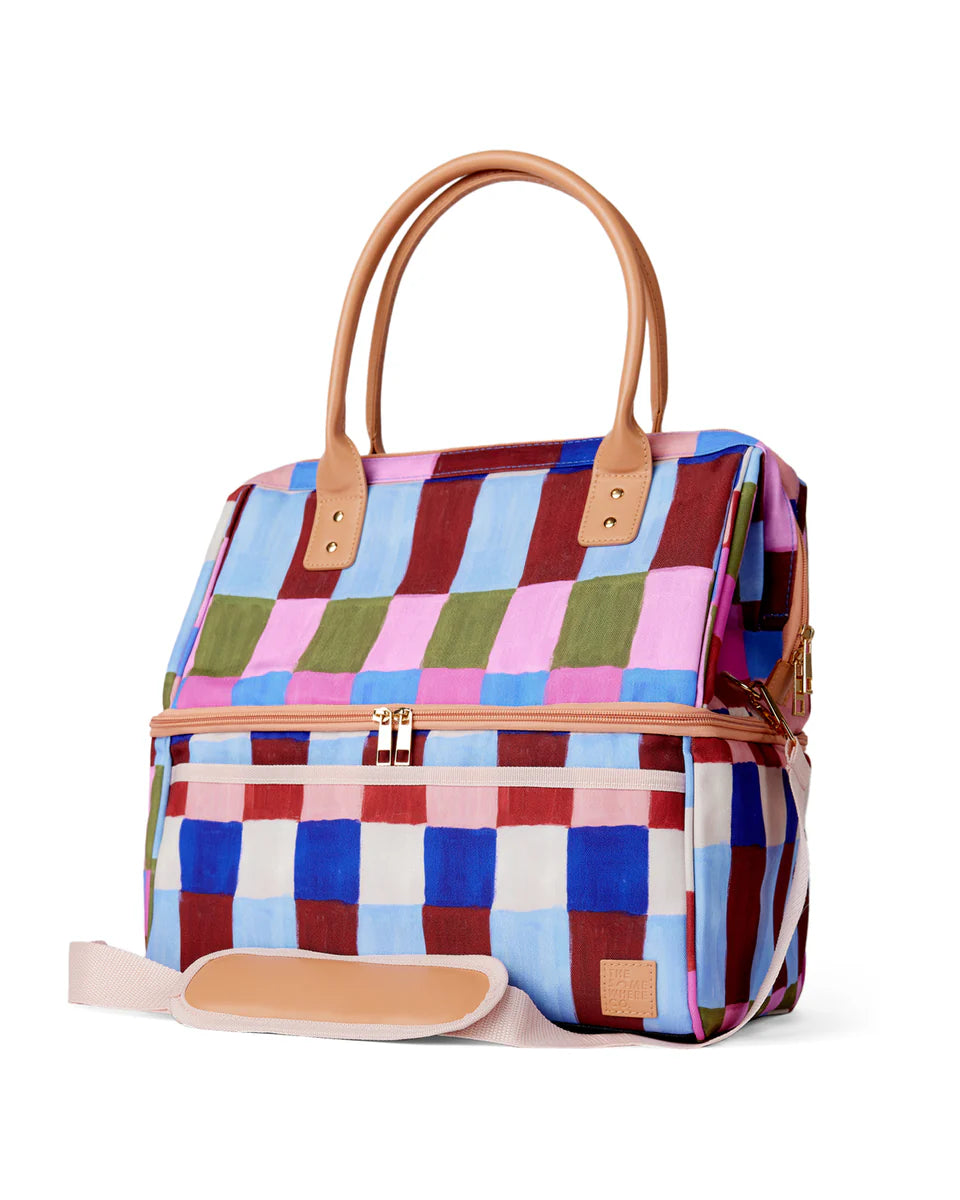 Colorful checkered bag with brown handles and trim on a white background