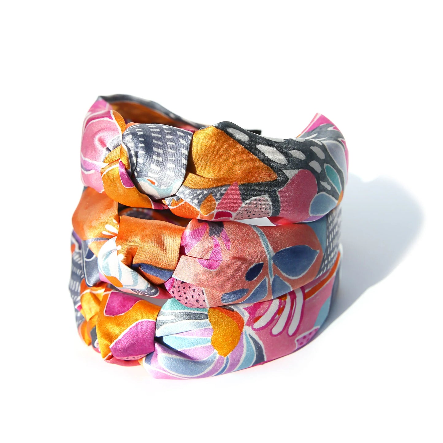 Stack of silk headbands with white background.
