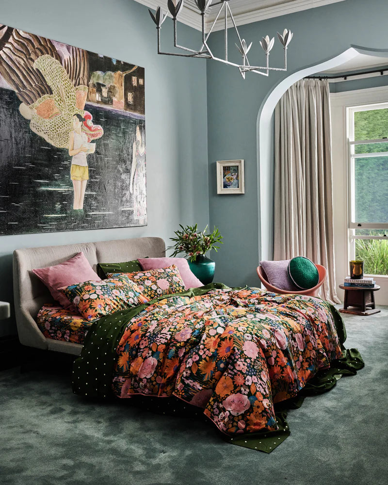 Bedroom with floral bedding and colorful decor in a cozy setting.