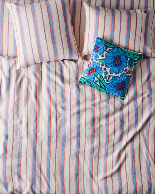 Striped bedding with a floral pillow on top