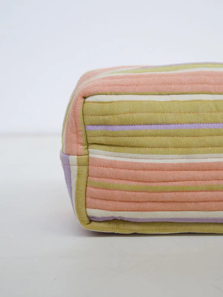 Rectangular quilted fabric block with multicolored stripes on a light gray background