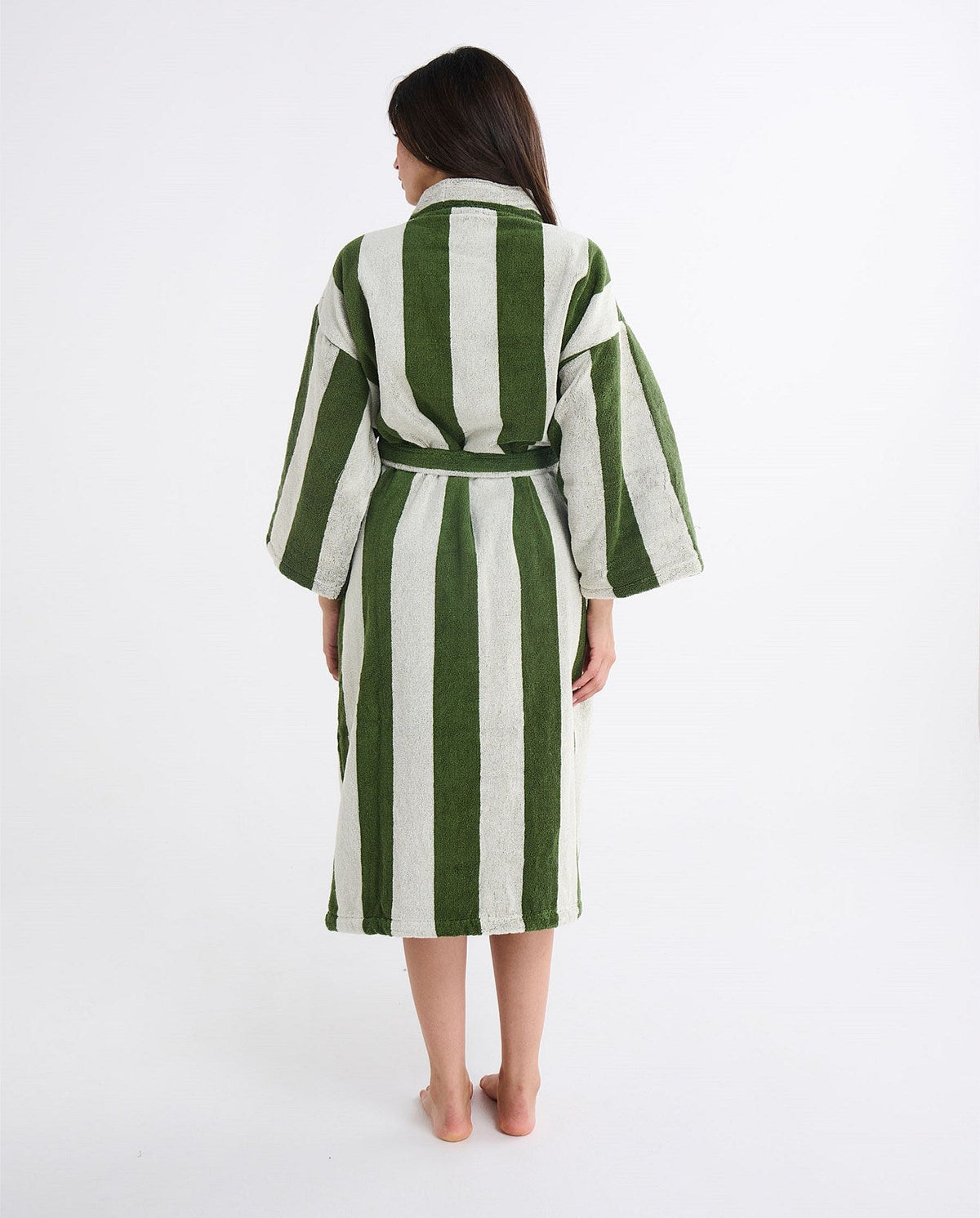 Woman wearing a green and white striped robe on a white background