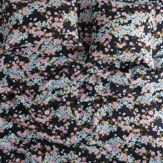 Floral patterned fabric with pink and blue flowers on a black background
