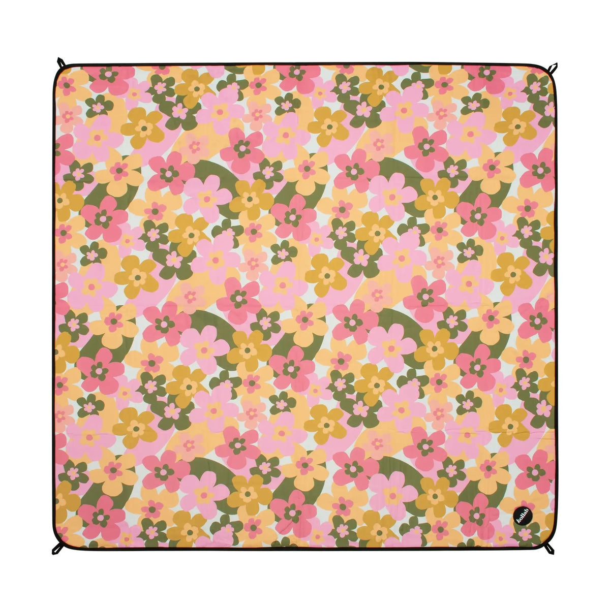 A square picnic blanket featuring a retro 1970s floral pattern with pink, yellow, and green flowers on a light pink background, finished with a black stitched border and grommets in the corners.