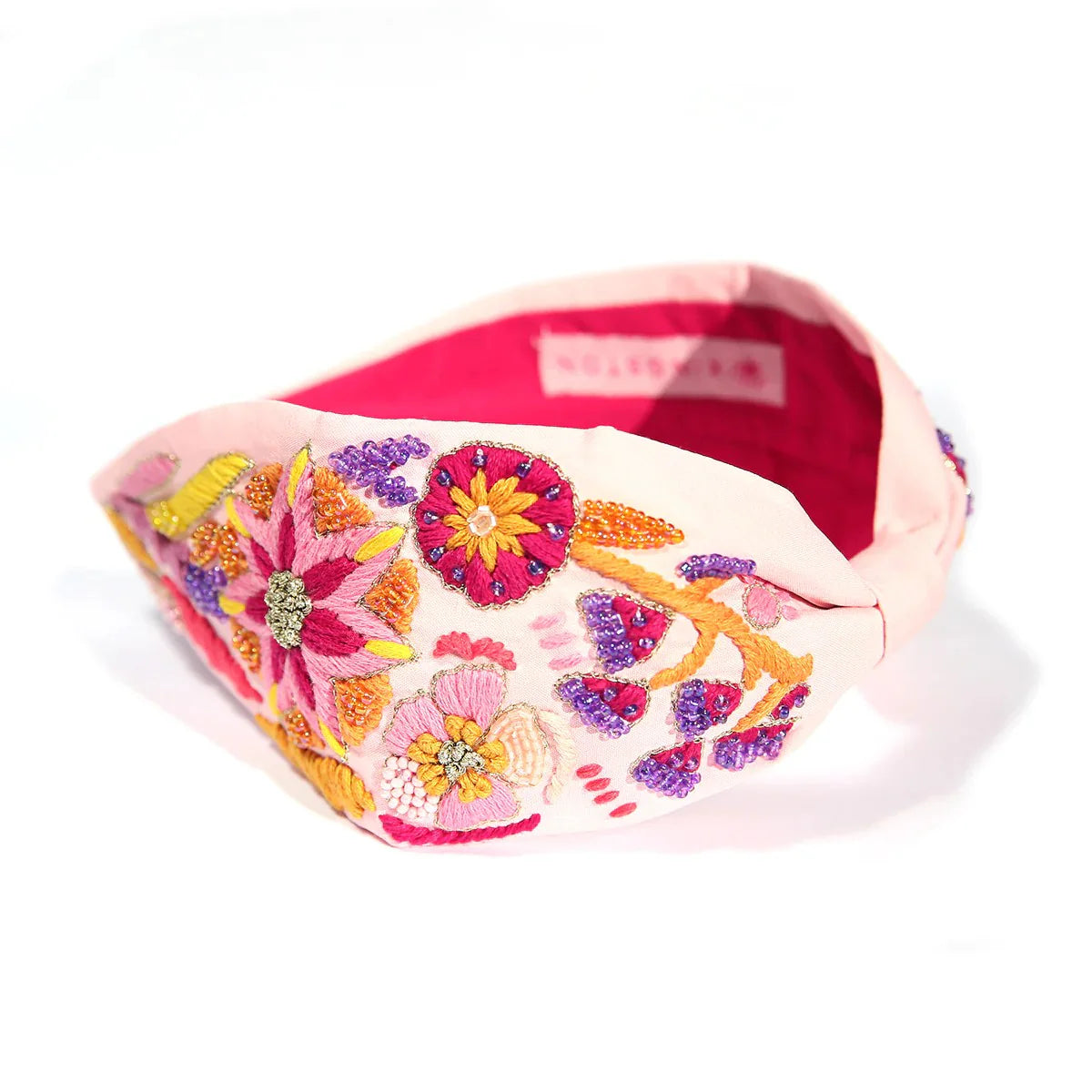 A pink embroidered beaded headband with colorful floral patterns on the band, displayed against a white background.