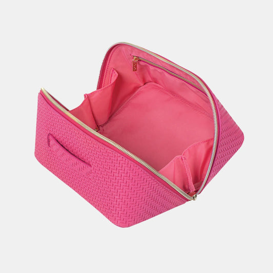 Pink textured toiletry bag with gold zipper on a light gray background