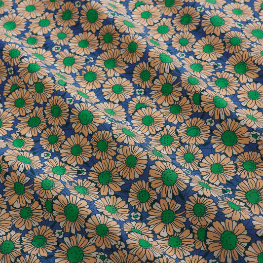 Pattern of peach and white flowers with green centers on a blue background