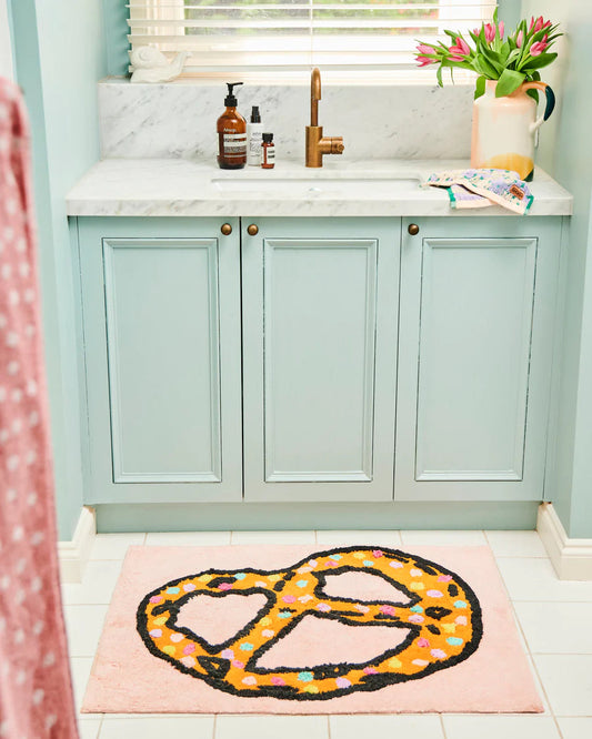 Bathroom with a decorative rug featuring a pretzel design and pale pink base colour.