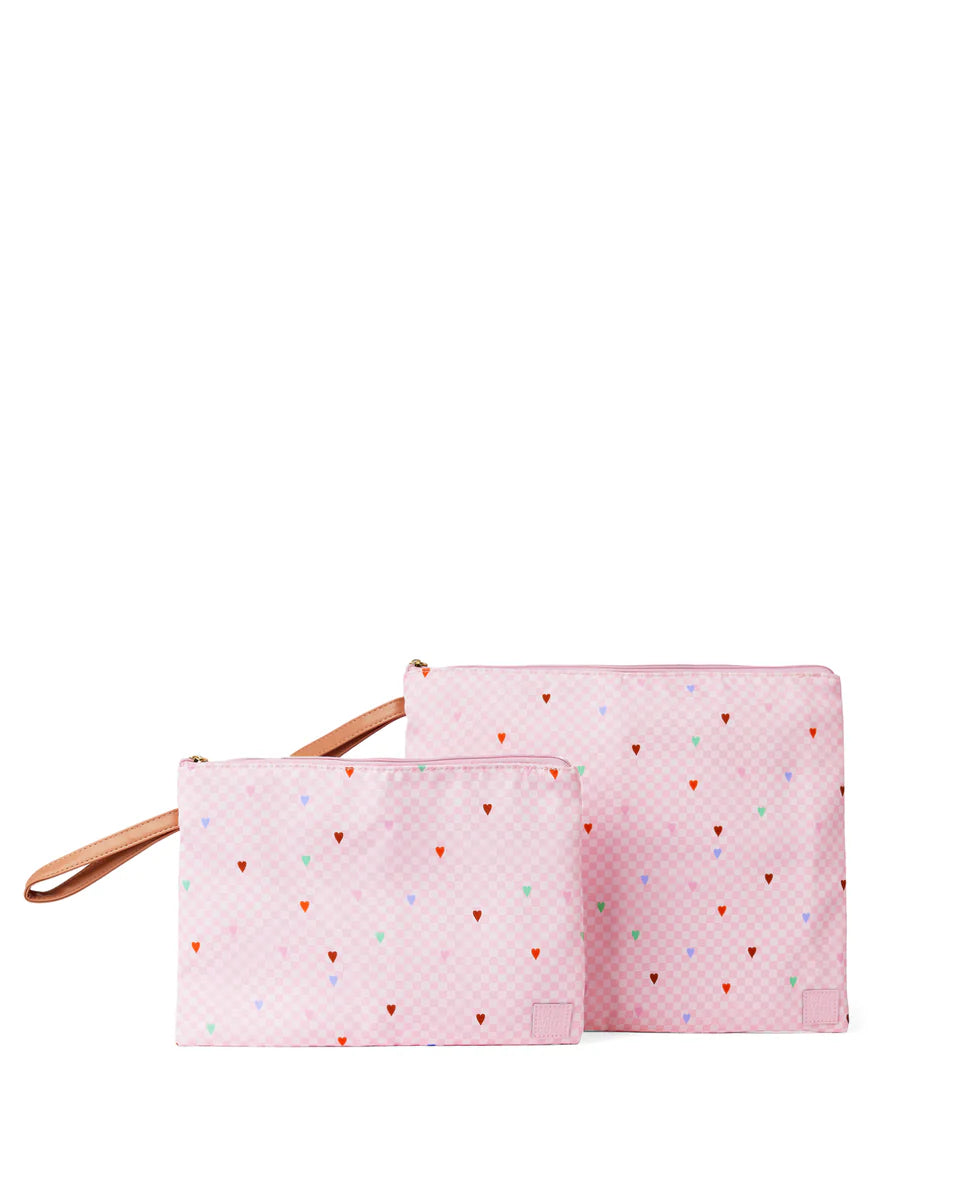 Two pink pouches with colorful heart patterns on a white background