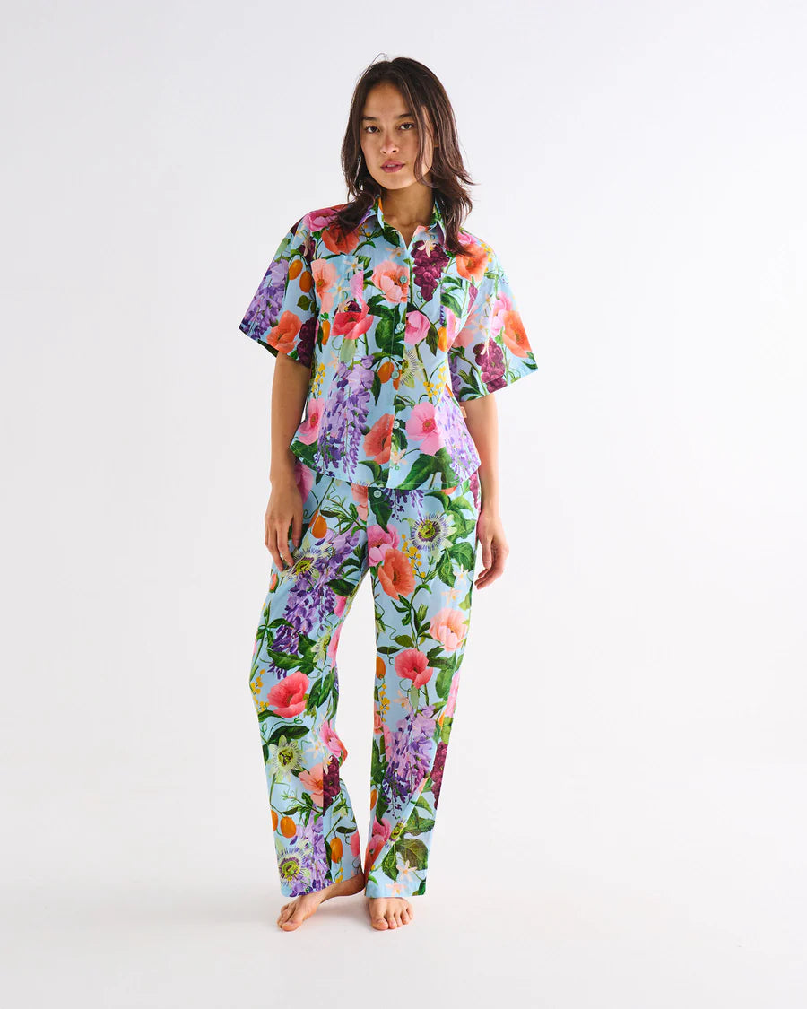 Woman wearing a colorful floral pajama set on a white background