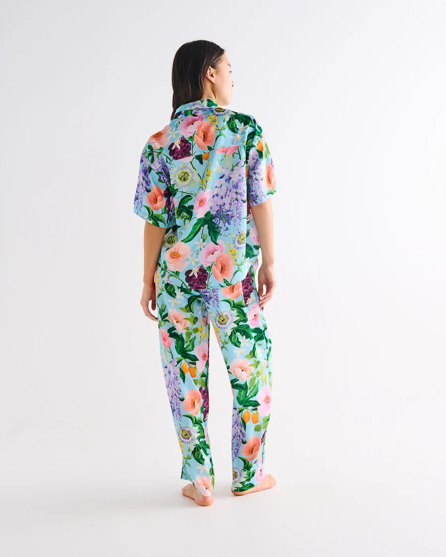 Woman wearing a floral pajama set on a white background