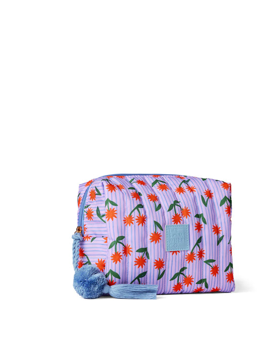 Floral patterned pouch with pom-pom details on a white background