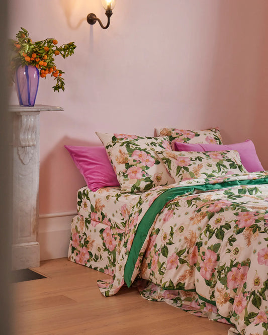 Bed with matching sheets, pillowcases and quilt cover in Sunday Stroll print - has cream base, with cream, pink and green rose floral print. Also has pink velvet pillowcases on bed.
