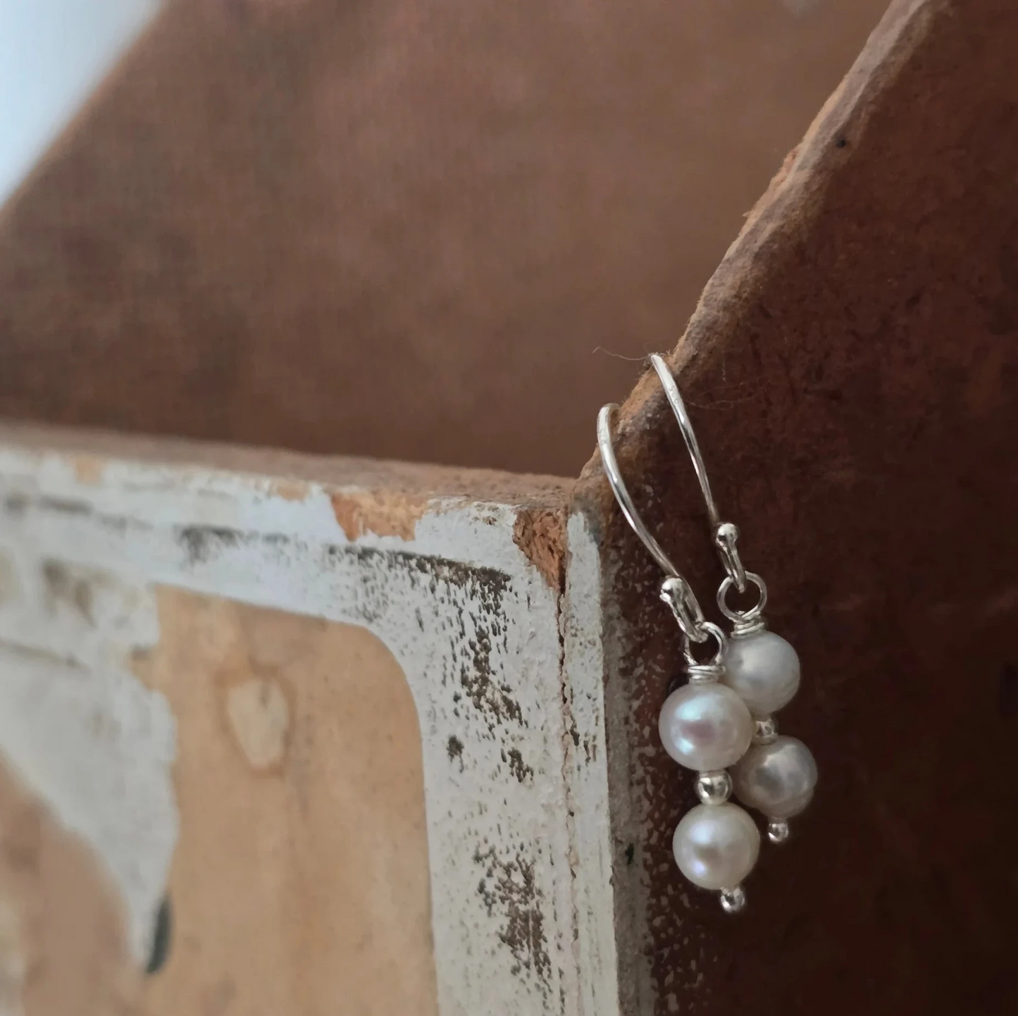 Pearl earring on a rustic wooden surface