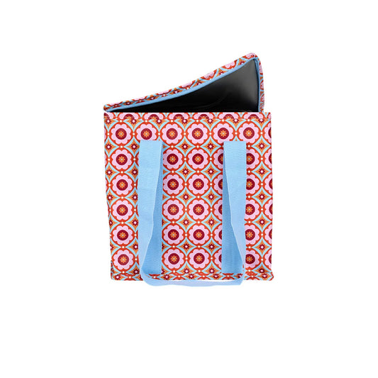 Pink and red tile flower patterned tote bag with blue handles on a white background