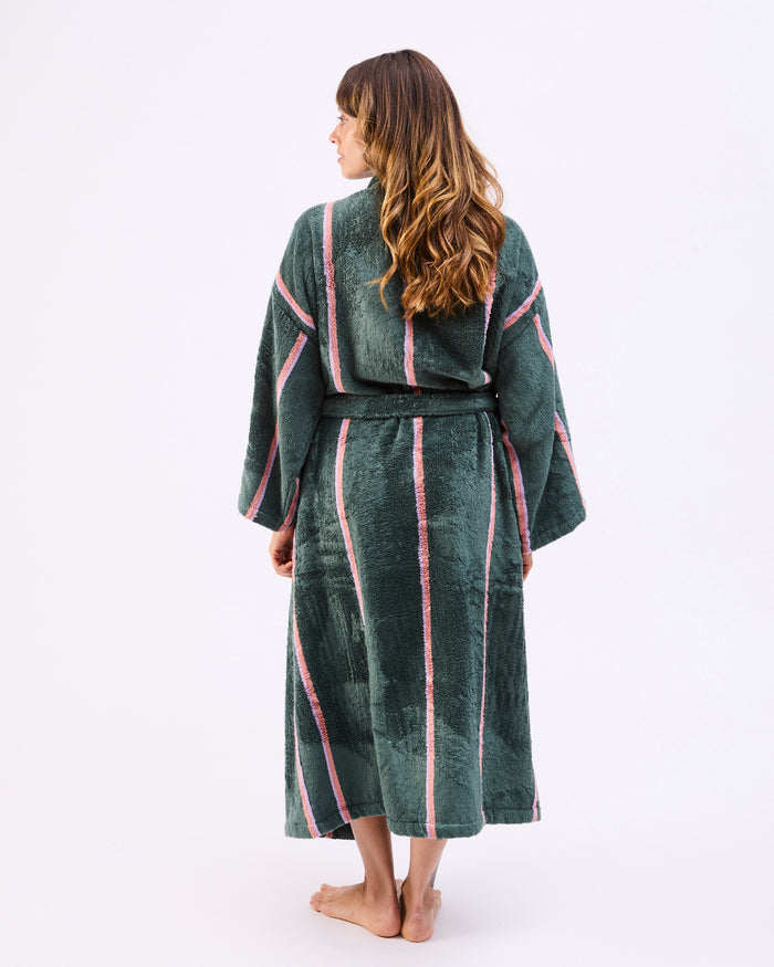 Woman wearing a green and pink striped robe on a white background