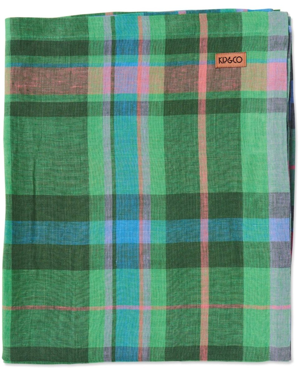 A rectangular linen tablecloth featuring a tartan pattern with green, blue, pink, and purple stripes.