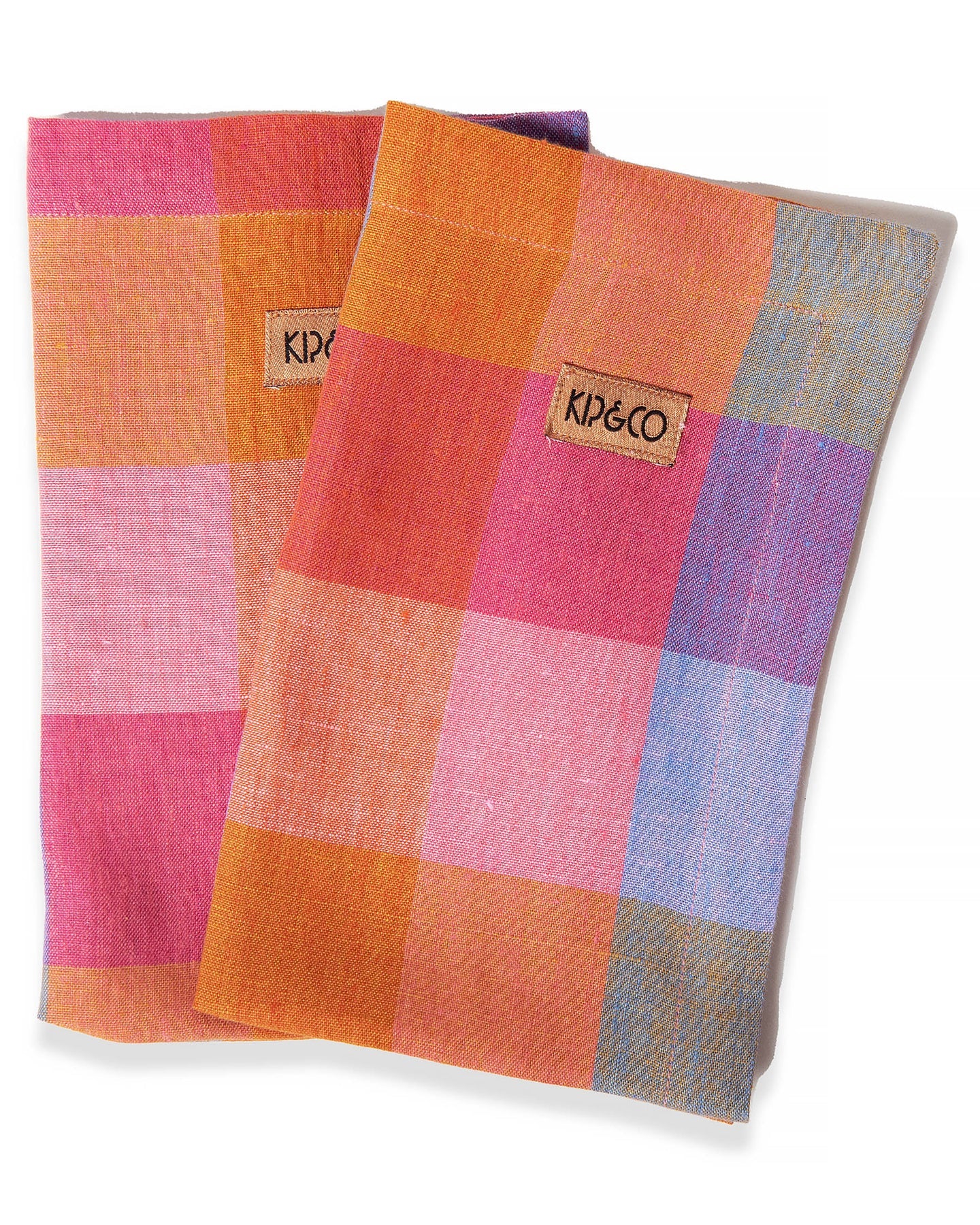 A set of four linen napkins with a pink, purple, blue, and orange check tartan pattern.