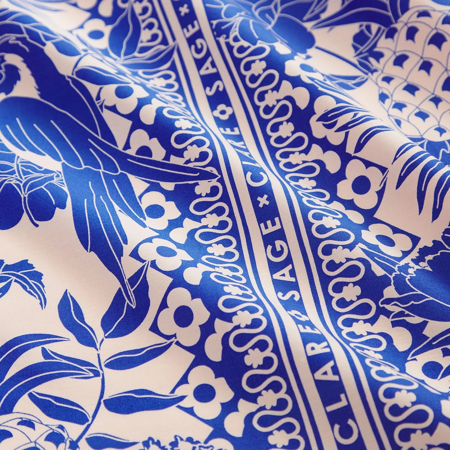 Close-up of blue and white patterned fabric with visible branding.