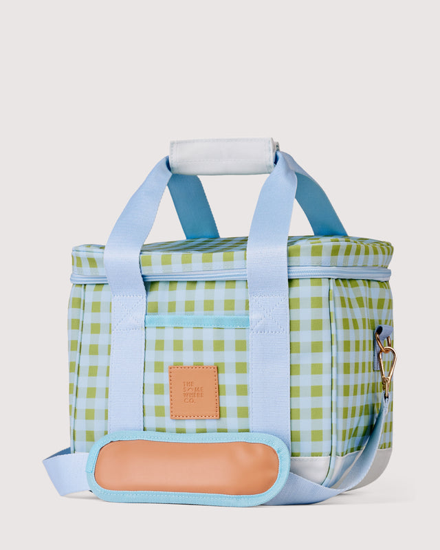 Checkered cooler bag with blue straps on a light gray background