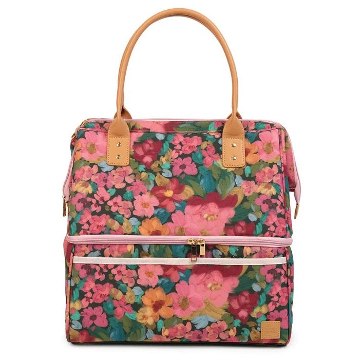 A structured tote bag with a vibrant pink, red, and orange floral print, tan leather handles, and a pink zipper closure on a white background.