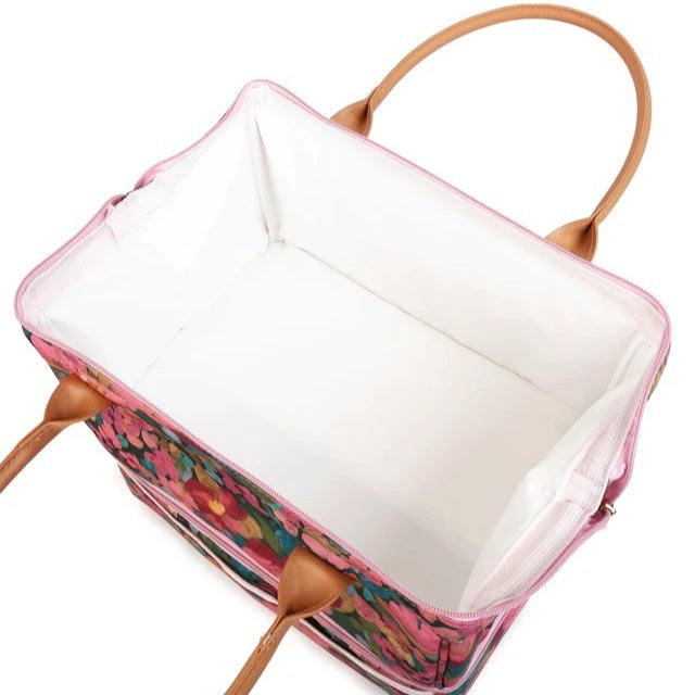 A rectangular tote bag with a pink floral exterior, tan leather handles, and a white interior lining, shown on a plain white background.
