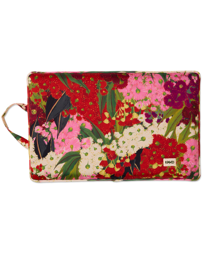 A rectangular fabric pouch with a vibrant floral print featuring red, pink, white, and green flowers with a small white 'UNIQ' brand label on the bottom right, set against a plain white background.