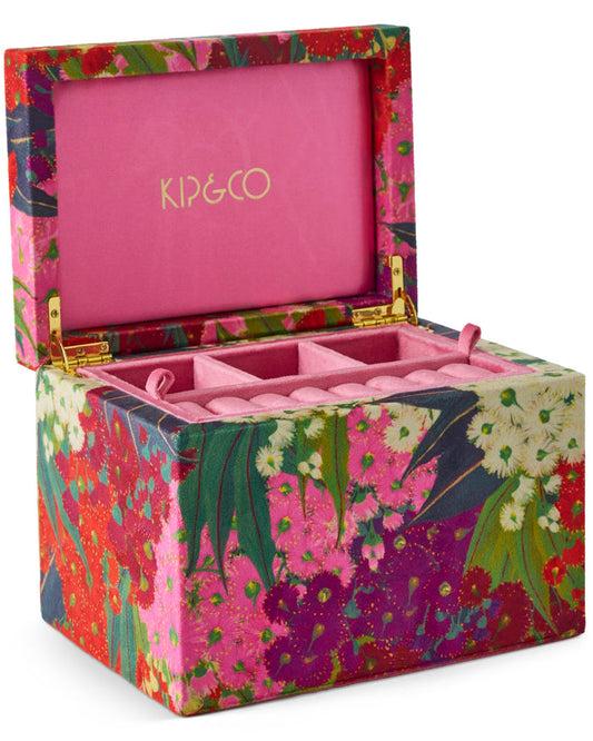 A KIP&CO brand jewelry box with a vibrant multicolor floral patterned exterior, a bright pink interior, and gold-tone hinges, shown open on a white background.