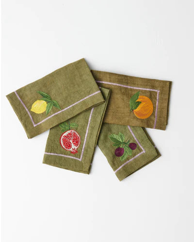 set of four green napkins with embroidery detail including lemon, pomegranate, grapes and orange. 