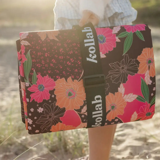 Floral-patterned bag with 'kollab' branding held by a person outdoors.