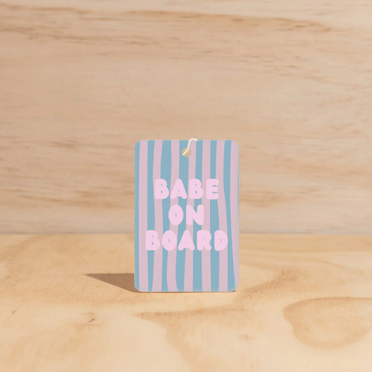 Car Freshener with 'Babe on Board' text on a wooden surface