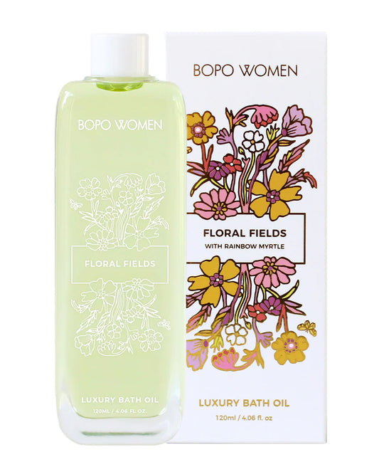 A bottle of 'BOPO WOMEN Floral Fields Luxury Bath Oil' with a floral design on the label, indicating a refreshing and natural scent profile.