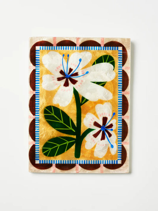 Decorative shell tile with floral design on a white background